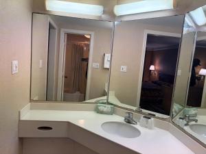 a bathroom with two sinks and a large mirror at America's Inn Houston/Stafford /Sugarland in Houston