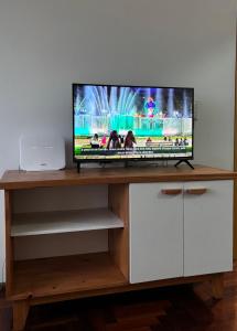 a flat screen tv sitting on top of a wooden entertainment center at La Plaza Apart in Mendoza