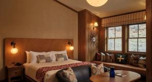 a bedroom with a bed and a couch and windows at Sundance Mountain Resort in Sundance