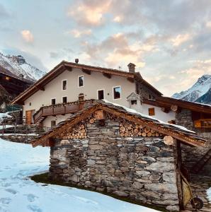 a house in the snow in front of a mountain at Lo Péyo - Le Four des Alpes in Rhemes-Saint-Georges +19 photos