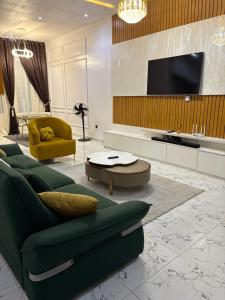 a living room with a green couch and a tv at Fukusu II in Ikuata