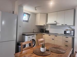 a kitchen with a wooden table and a white refrigerator at Rosalia28 in Antigua