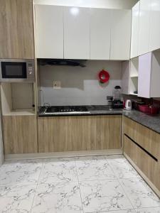 a kitchen with white cabinets and a counter top at Fukusu II in Ikuata