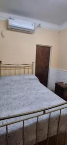 a bedroom with a bed with a air conditioner on the wall at El limonero in Paso de los Libres