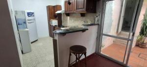 a small kitchen with a stool and a sink at El limonero in Paso de los Libres