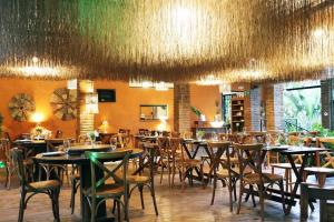 a dining room with tables and chairs in a restaurant at Casa das Flores Bistrô e Pousada in Taquarussu Tocantins