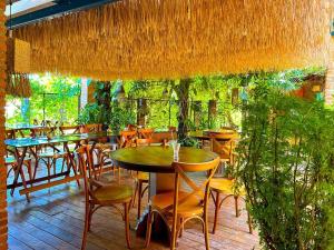 a restaurant with tables and chairs and plants at Casa das Flores Bistrô e Pousada in Taquarussu Tocantins