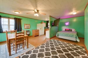 a bedroom with green walls and a table and a bed at Couple’s Retreat w/ Dock Access on Lake Eufaula! in Georgetown