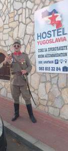 a man in uniform standing in front of a sign at Yugoslavija Lux 3 in Aleksandrovac