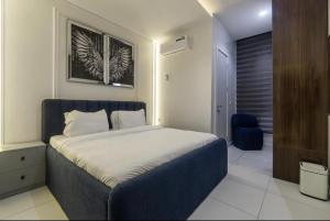 a bedroom with a bed with a blue head board at Olaz holmes in Lagos
