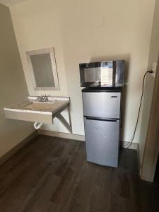a small kitchen with a sink and a microwave at Western Lodge Phoenix Airport/Downtown in Phoenix