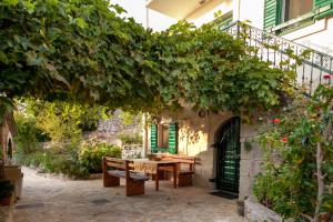 an outdoor patio with a table and a tree at Holiday Home Alegra in Podgora +28 photos