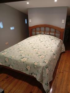 a bedroom with a bed with a floral bedspread at Panchitas in Guaymallen