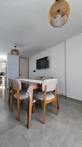 a dining room with a table and chairs and a television at Departamento BARBÚ in Villa María