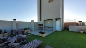 a room with chairs on a balcony with green grass at Departamento BARBÚ in Villa María
