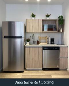 a kitchen with a stainless steel refrigerator and cabinets at Narama 1 - Apartamento cerca del aeropuerto - Zona 13 de la Ciudad de Guatemala in Estación Pamplona