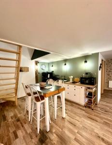 a kitchen with a table and chairs in a room at La Pastourelle en Lozère in Le Bacon