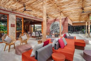 a living room with a red couch and chairs at Moxy Tulum in Tulum