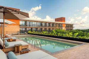 a building with a swimming pool and a resort at Moxy Tulum in Tulum
