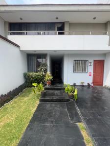 a house with a red door and a yard at Lima Mini Aparts Monterrico - Cerca Embajada EEUU in Lima
