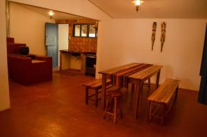 a living room with a wooden table and benches at Casarão Duque do Mel in João Pessoa