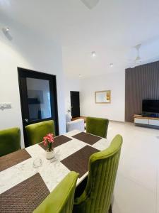a dining room with a table and green chairs at Santorini Transit hotel in Negombo