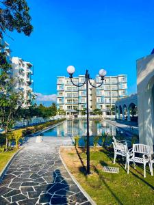 a street light next to a swimming pool with buildings at Santorini Transit hotel in Negombo