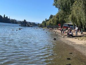 a group of people on a beach in the water at La casa de Belén in Valdivia