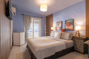 a bedroom with a large bed and a refrigerator at Pousada dos Gravatás in Búzios