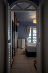 a bedroom with a bed in a room with a window at Pousada dos Gravatás in Búzios