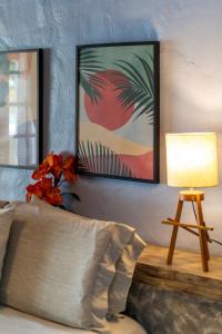 a living room with a bed and a lamp and a table at Pousada dos Gravatás in Búzios