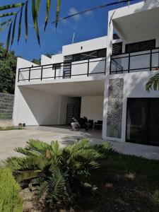 a white house with a motorcycle parked in front of it at Casa BOSQUE LUCIERNAGAS in Bacalar