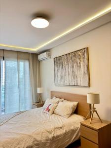 a bedroom with a bed and a painting on the wall at Le murmure in Oulad Akkou