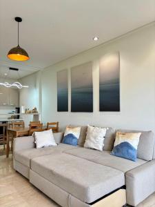 a living room with a large couch and a kitchen at Le murmure in Oulad Akkou
