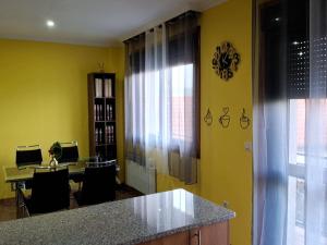 a kitchen with yellow walls and a desk with a computer at Suseia in Arcade +17 photos
