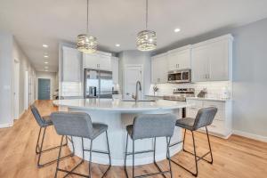 a kitchen with a large white island with chairs at Stillwater 113 in Arnolds Park +41 photos