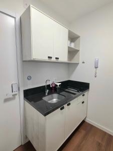 a kitchen with a sink and white cabinets at Apto confortável Centro/Batel in Curitiba +126 photos