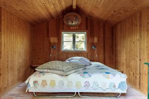 a bedroom with a bed in a room with a window at Authentic Summerhouse Near The Beach in Rørvig