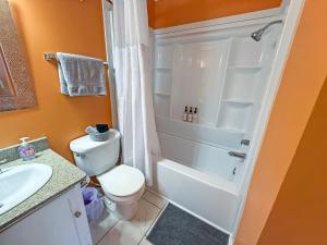 a bathroom with a white toilet and a shower at Portabella Paradise in Carolina Beach +9 photos