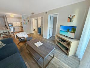 a living room with a couch and a flat screen tv at Portabella Paradise in Carolina Beach
