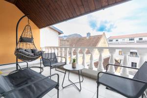 a balcony with chairs and a hammock on a building at COY Apartments Kapfenberg - Spacious Stays for Companies, Groups & Workers in Kapfenberg