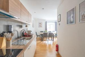a kitchen with a sink and a dining room at COY Apartments Kapfenberg - Spacious Stays for Companies, Groups & Workers in Kapfenberg