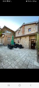 a stone building with a patio with tables and chairs at Yugoslavija 2 centar in Aleksandrovac