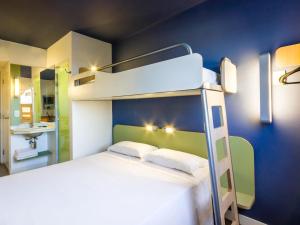 a bedroom with a bunk bed and a bathroom at ibis budget Sertaozinho in Sertãozinho