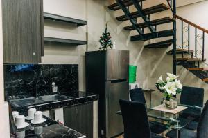 a kitchen with a refrigerator and a table with chairs at Rubi's House in Ilayang Talim