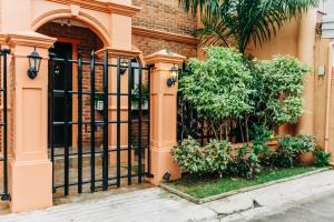 a fence in front of a building with plants at Rubi's House in Ilayang Talim
