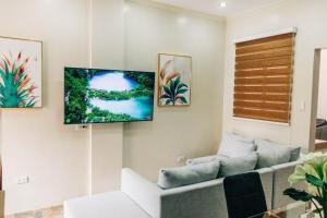 a living room with a couch and a flat screen tv at Rubi's House in Ilayang Talim