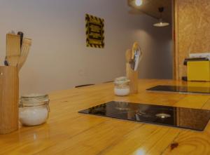 a kitchen with a counter with two jars on a wooden floor at Portela Room in Carnaxide