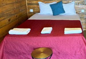 a bed with a red blanket and a table on it at Portela Room in Carnaxide