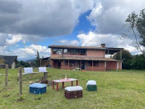 a house in a field with a table in front of it at Casa Campestre Familiar in Medellín
